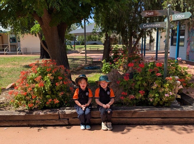 Photo shows some of our B4K students sitting in front of our garden modelling their uniform.